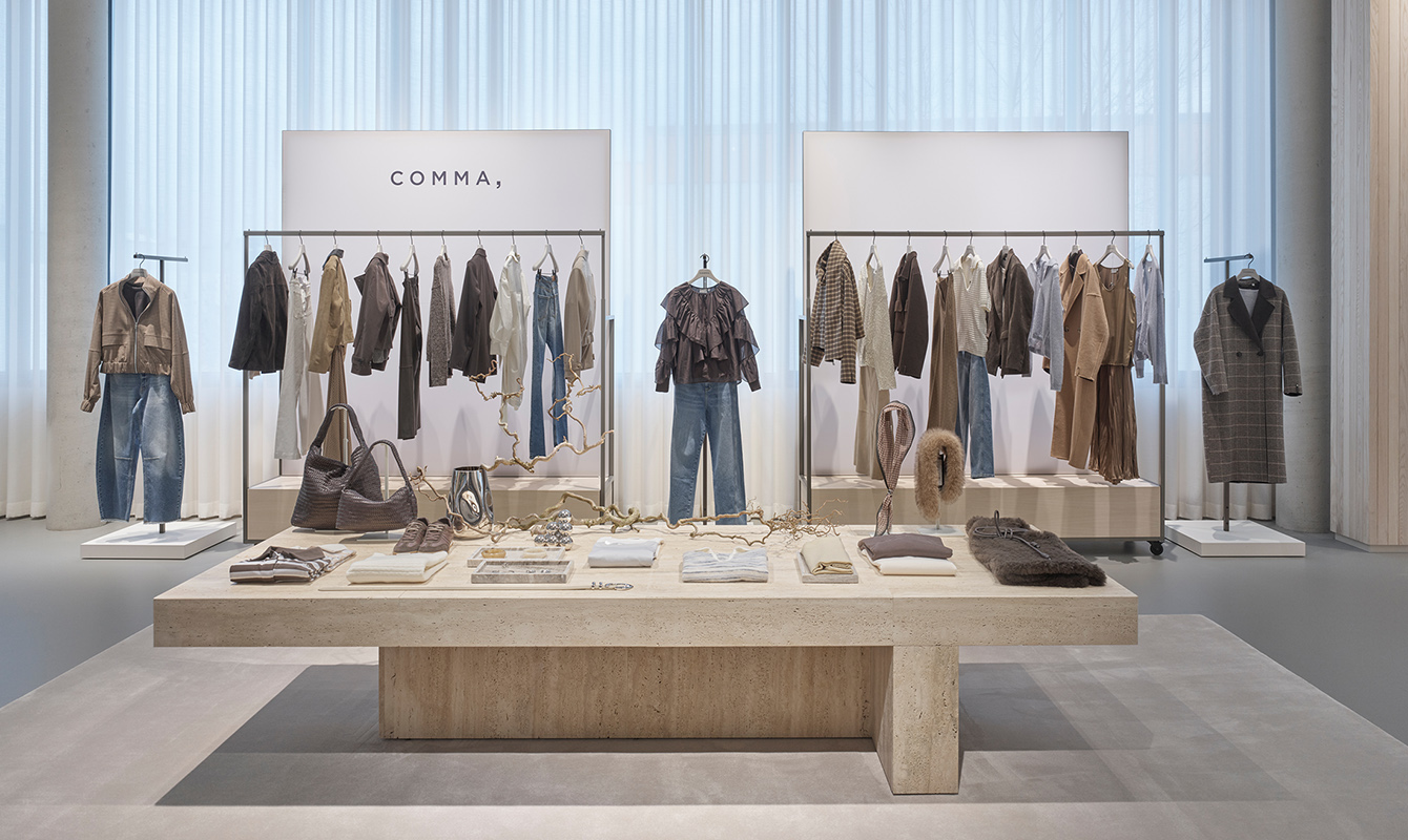 Auslage mit Kleidung auf einem niedrigen Steintisch.